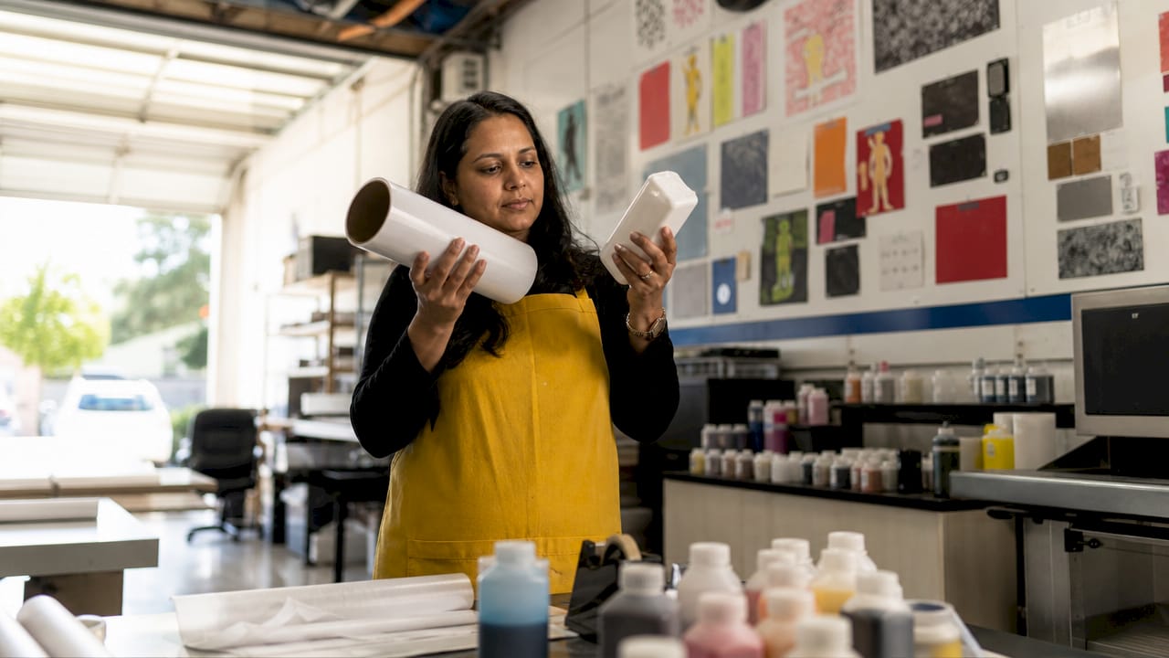 Woman inspecting DTF film and white ink cartridge