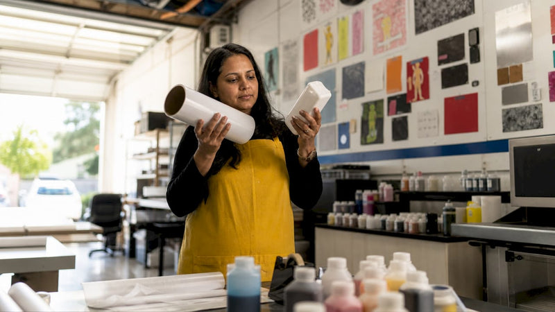 Woman inspecting DTF film and white ink cartridge