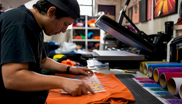 Hands applying colorful DTF transfers on fabric