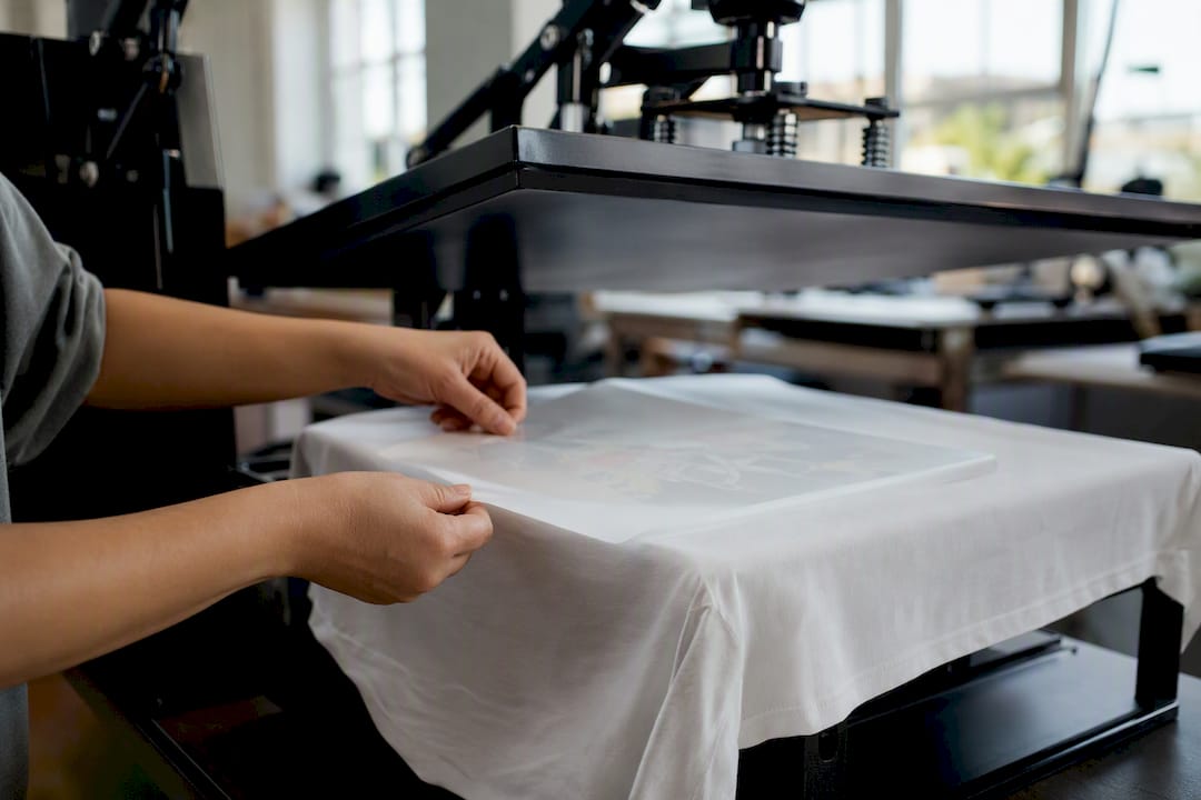 Hands placing DTF transfer on cotton fabric
