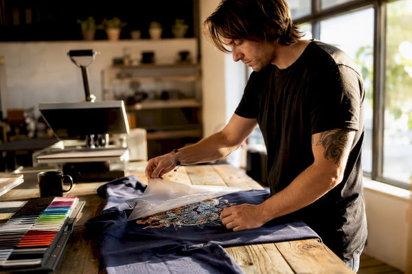 Hands peeling digital DTF transfer on fabric