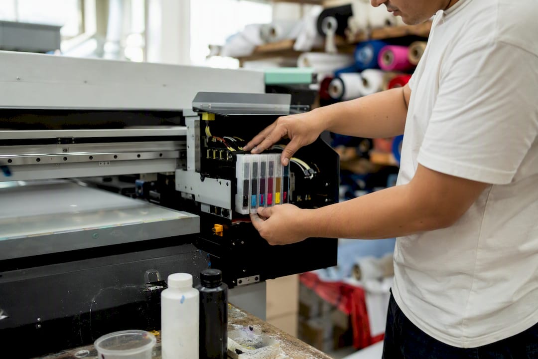 Technician loading UV ink cartridges into printer
