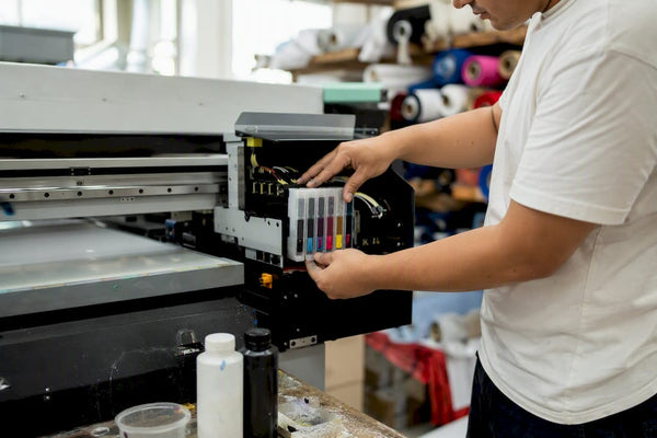 Technician loading UV ink cartridges into printer