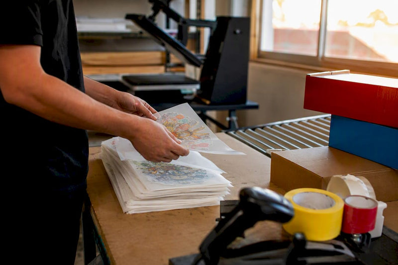 Hands loading DTF transfers for shipping