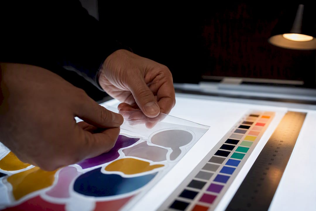Technician inspecting transparent sticker artwork
